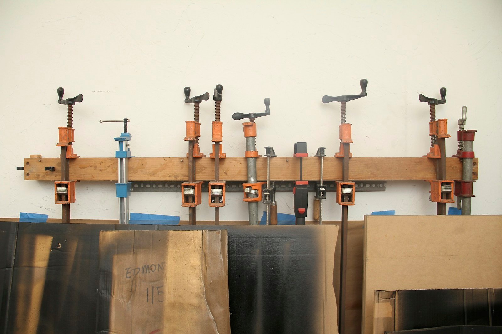 Différents types de serre-joints accrochés au mur d'un atelier de menuiserie