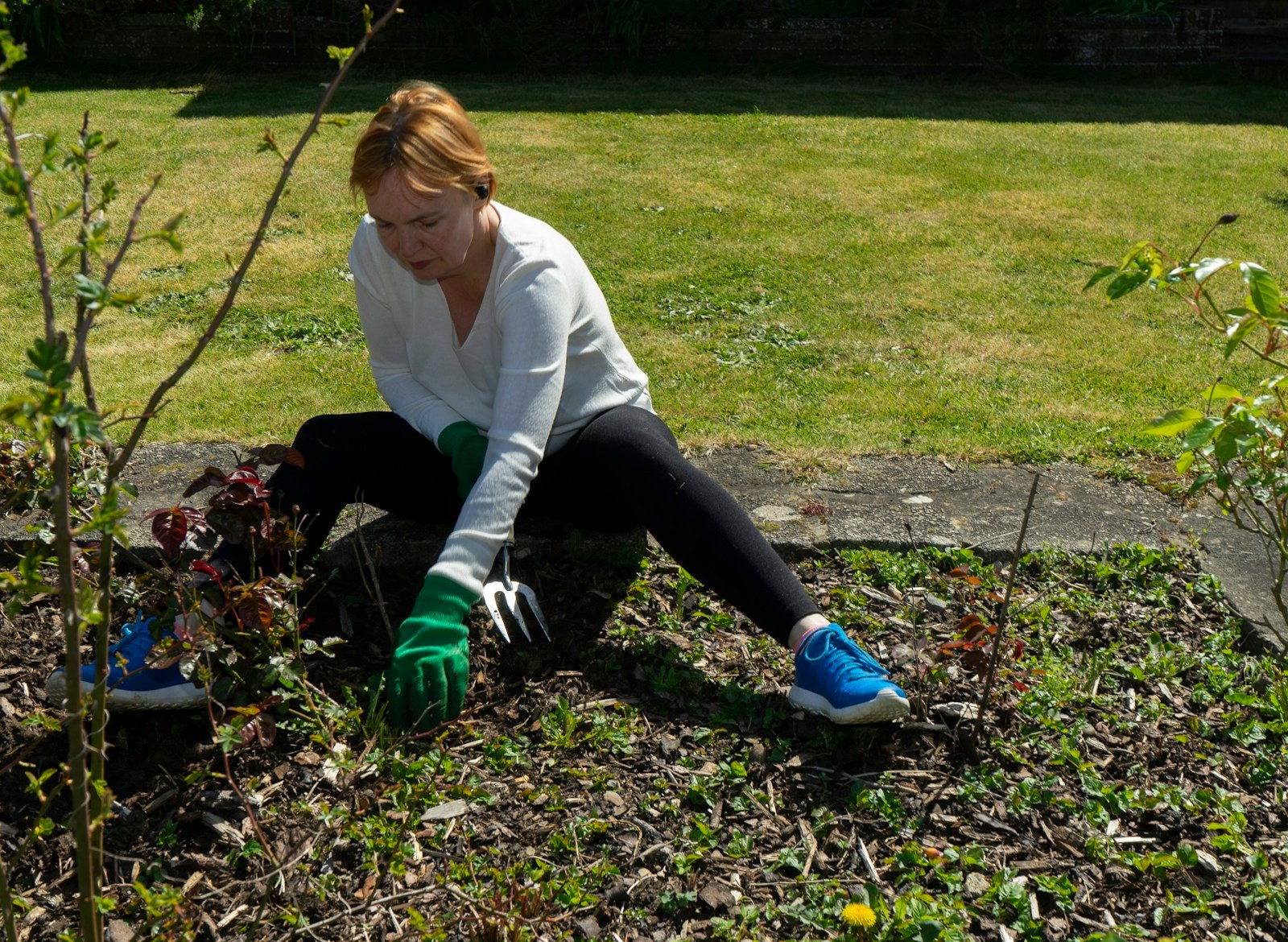 Gants et chaussures de jardinage fermées posés au bord d'une pelouse